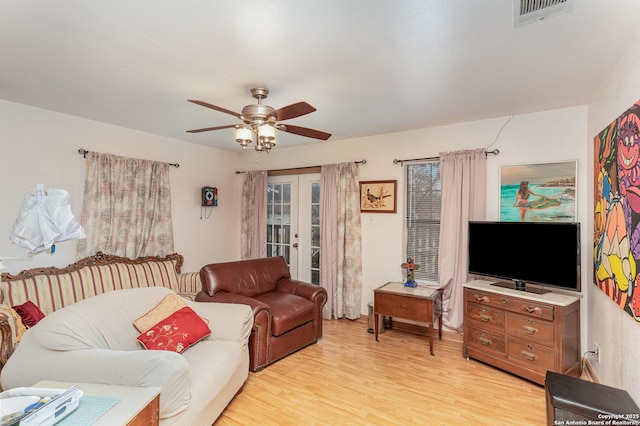 living room featuring ceiling fan, light hardwood / wood-style floors, and french doors