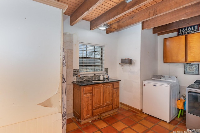 clothes washing area with sink, dark tile patterned floors, washing machine and dryer, cabinets, and wooden ceiling