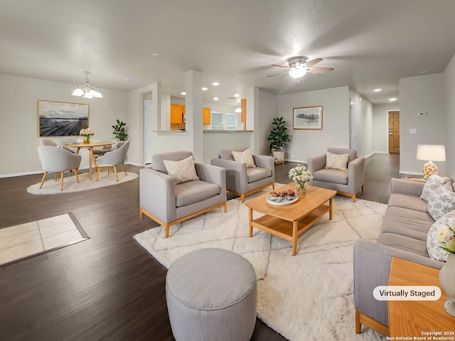 living room featuring hardwood / wood-style flooring and ceiling fan with notable chandelier