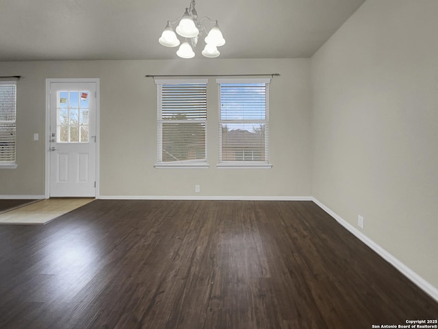 unfurnished dining area featuring dark wood-type flooring and a chandelier