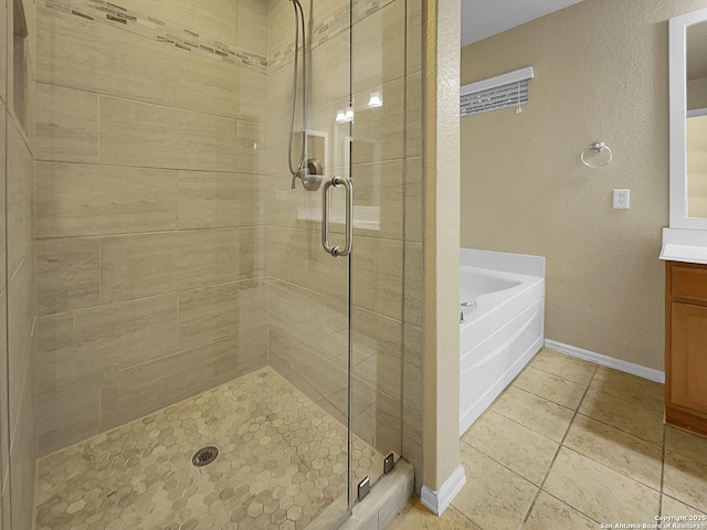 bathroom featuring plus walk in shower, vanity, and tile patterned floors