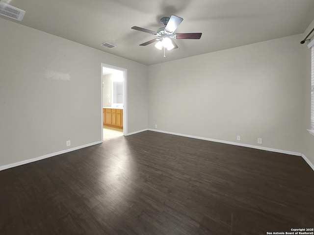 spare room with dark hardwood / wood-style flooring and ceiling fan