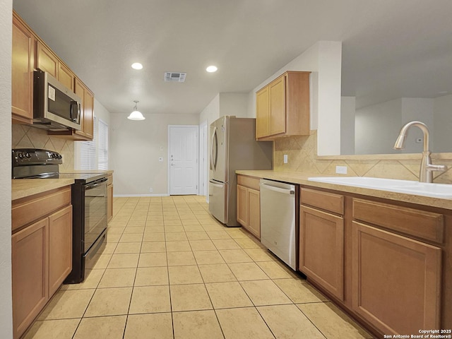 kitchen with sink, light tile patterned floors, stainless steel appliances, and backsplash