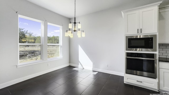 kitchen with built in microwave, hanging light fixtures, stainless steel oven, and white cabinets