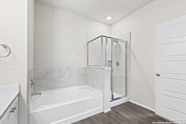 bathroom with vanity, hardwood / wood-style flooring, and plus walk in shower