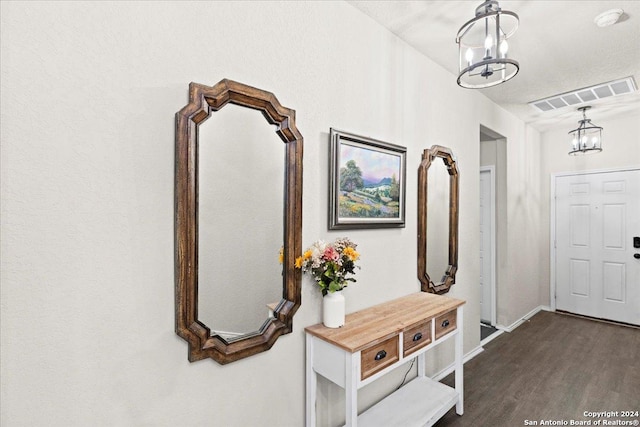 corridor featuring dark hardwood / wood-style floors and a notable chandelier