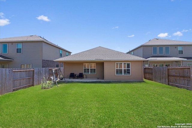 rear view of house featuring a yard and a patio area