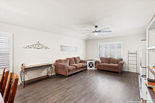 living room with ceiling fan, lofted ceiling, dark hardwood / wood-style floors, and a textured ceiling