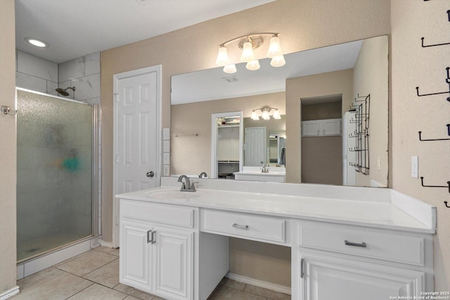 bathroom featuring tile patterned floors, vanity, and a shower with shower door