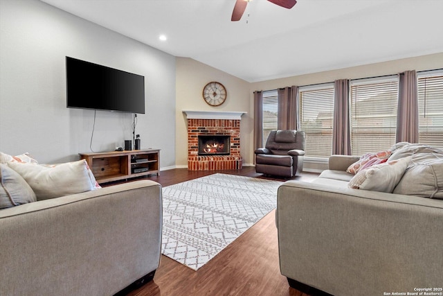 living room with lofted ceiling, a fireplace, dark wood-type flooring, and ceiling fan