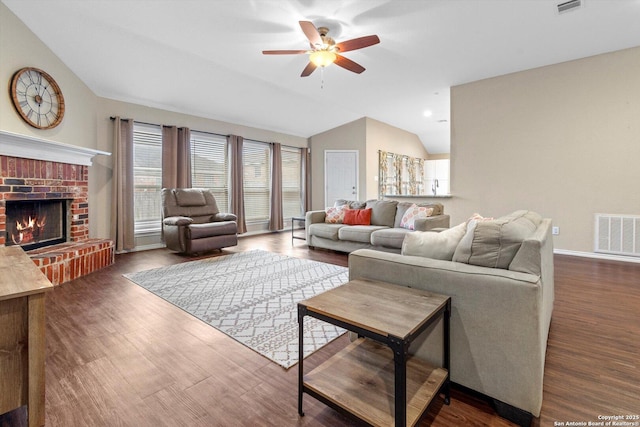 living room with lofted ceiling, a brick fireplace, dark hardwood / wood-style flooring, and ceiling fan