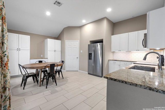 kitchen featuring stainless steel appliances, stone countertops, sink, and white cabinets