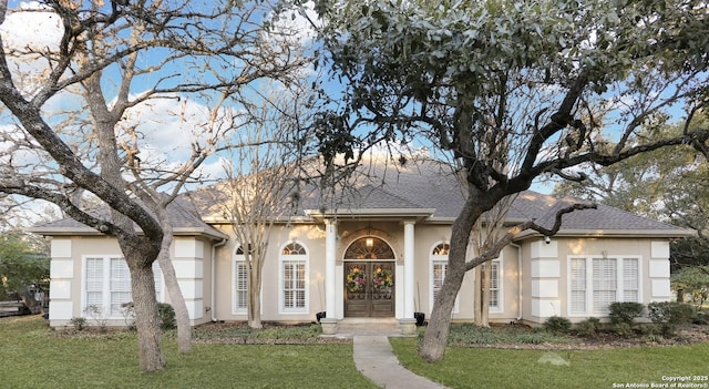 single story home with a front yard and french doors