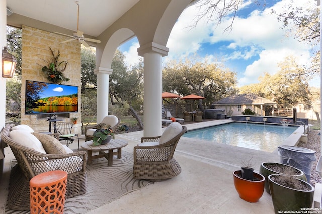 view of pool featuring pool water feature, an outbuilding, ceiling fan, and a patio area