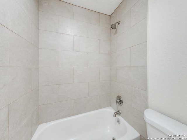 bathroom with tiled shower / bath and toilet