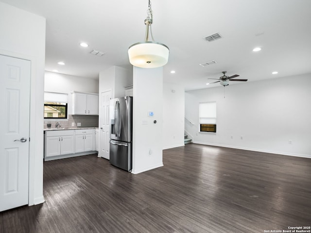 kitchen with dark wood-type flooring, backsplash, hanging light fixtures, white cabinets, and stainless steel fridge with ice dispenser