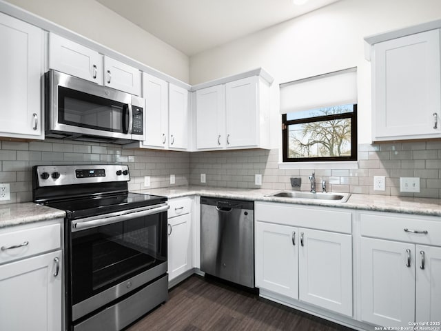 kitchen with white cabinetry, appliances with stainless steel finishes, sink, and decorative backsplash