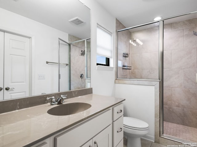 bathroom with vanity, a shower with shower door, and toilet