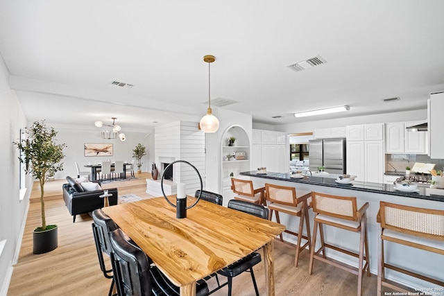 dining space with a chandelier and light hardwood / wood-style flooring