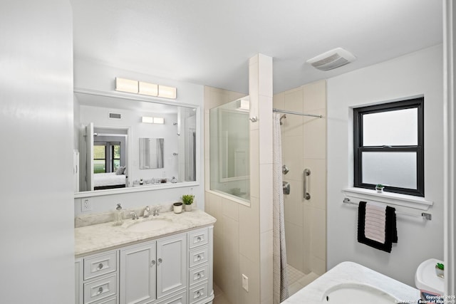 bathroom featuring tiled shower and vanity