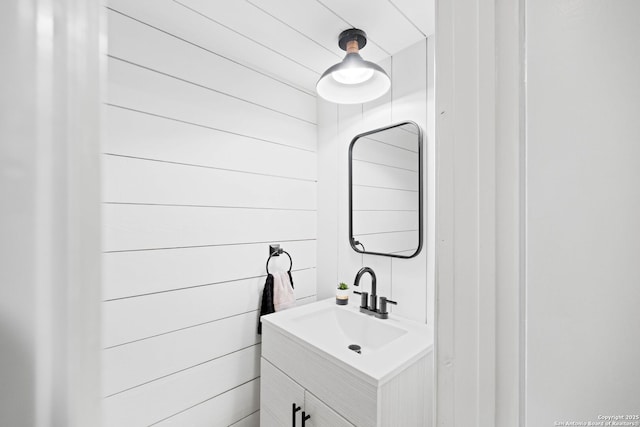 bathroom featuring vanity and wood walls