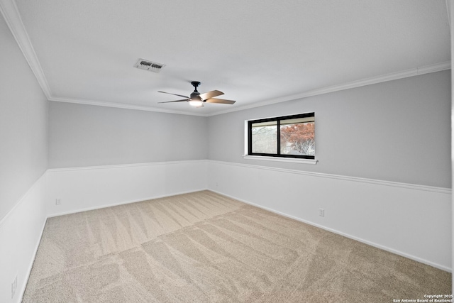 empty room with crown molding, ceiling fan, and carpet flooring