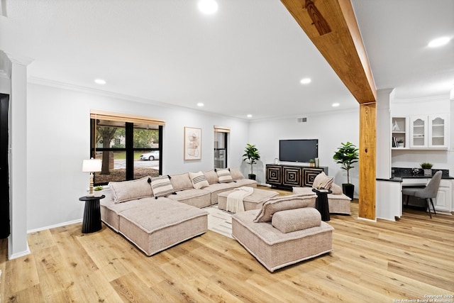 living room featuring ornamental molding and light hardwood / wood-style floors