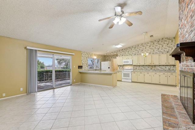 kitchen featuring vaulted ceiling, light tile patterned flooring, kitchen peninsula, cream cabinets, and white appliances