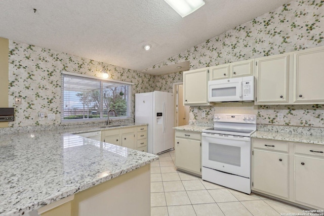 kitchen with sink, white appliances, light tile patterned floors, vaulted ceiling, and cream cabinetry