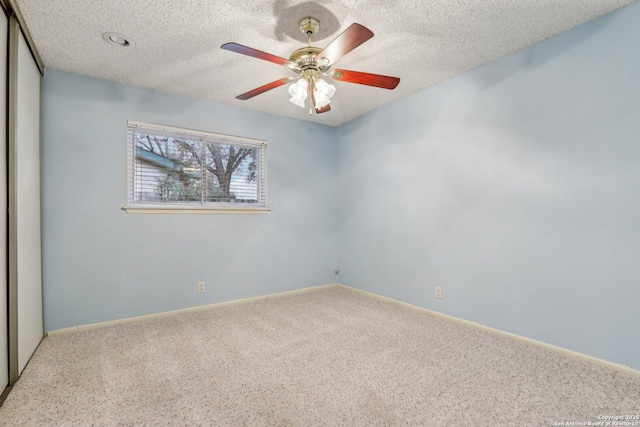 unfurnished room with ceiling fan, carpet floors, and a textured ceiling