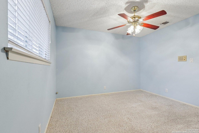 empty room with ceiling fan and a textured ceiling