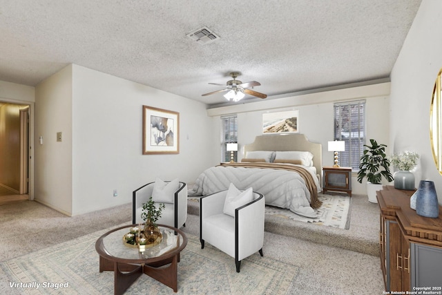 carpeted bedroom featuring ceiling fan, multiple windows, and a textured ceiling