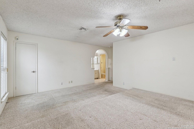 carpeted empty room featuring ceiling fan and a textured ceiling