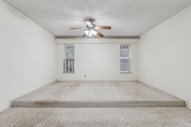 unfurnished room featuring a textured ceiling, ceiling fan, and carpet flooring