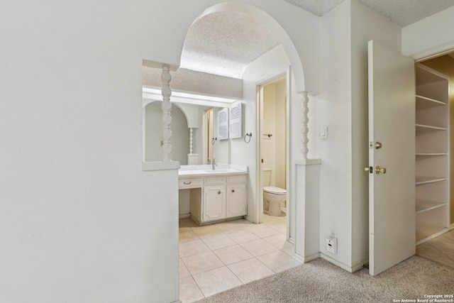 bathroom with vanity, tile patterned floors, a textured ceiling, and toilet