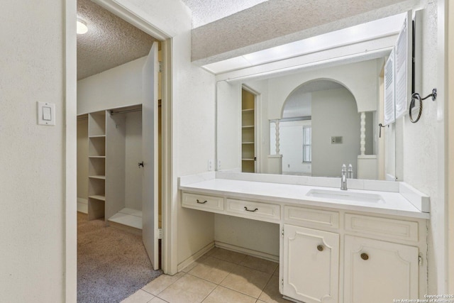 bathroom featuring vanity, tile patterned floors, and a textured ceiling