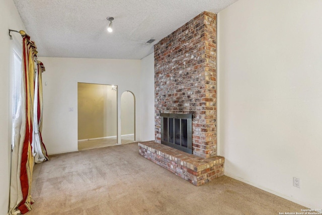 unfurnished living room with a fireplace, a textured ceiling, and carpet