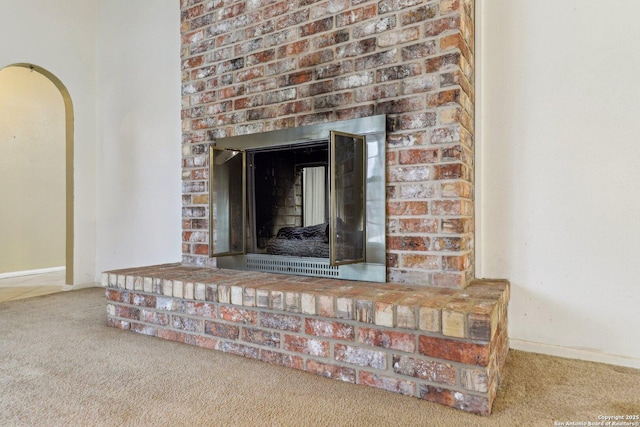 details with a brick fireplace and carpet