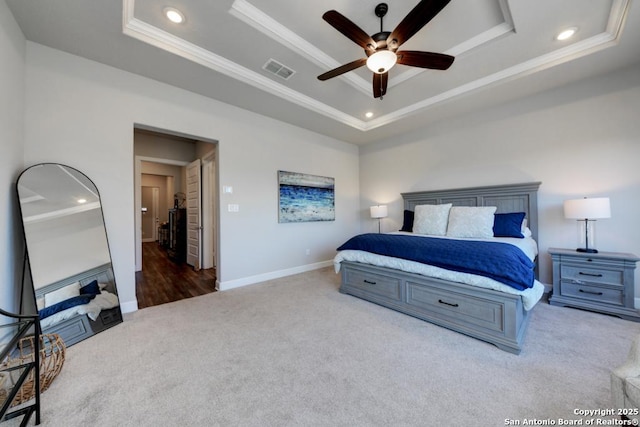 bedroom with crown molding, carpet floors, ceiling fan, and a tray ceiling