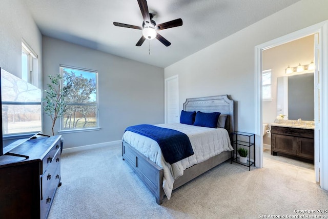 carpeted bedroom with ceiling fan and ensuite bath