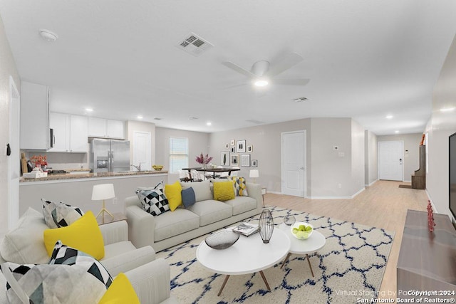 living room featuring ceiling fan and light wood-type flooring