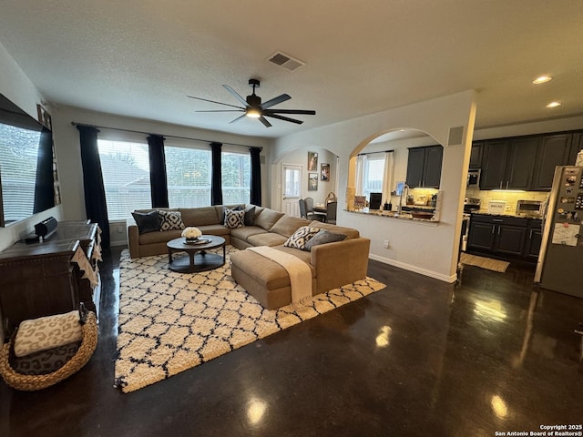 living room featuring a textured ceiling and ceiling fan