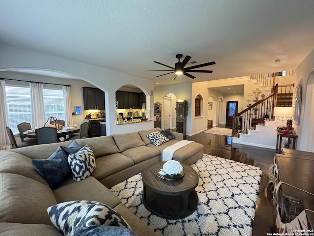 living room featuring ceiling fan and a textured ceiling