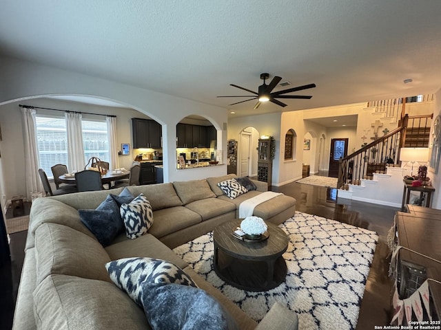 living room featuring dark hardwood / wood-style flooring, ceiling fan, and a textured ceiling