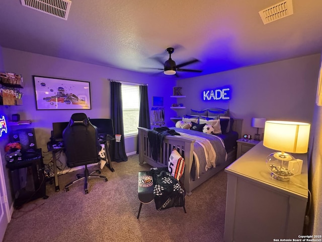 carpeted bedroom featuring ceiling fan and a textured ceiling