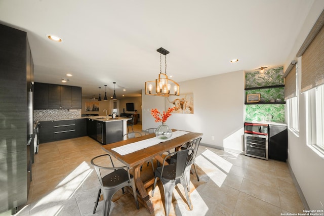 tiled dining room with wine cooler, sink, and an inviting chandelier