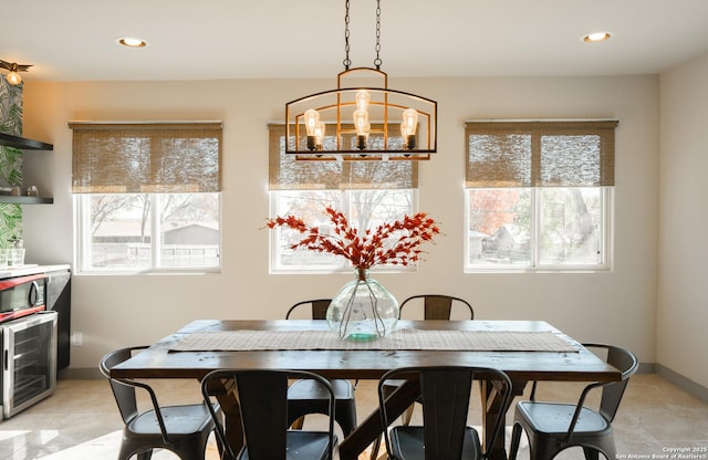 dining space featuring an inviting chandelier, beverage cooler, and a healthy amount of sunlight