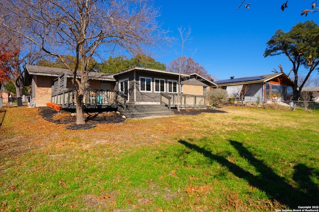 rear view of property with a lawn and a deck