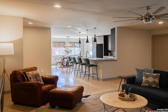 living room with light tile patterned floors, sink, and ceiling fan