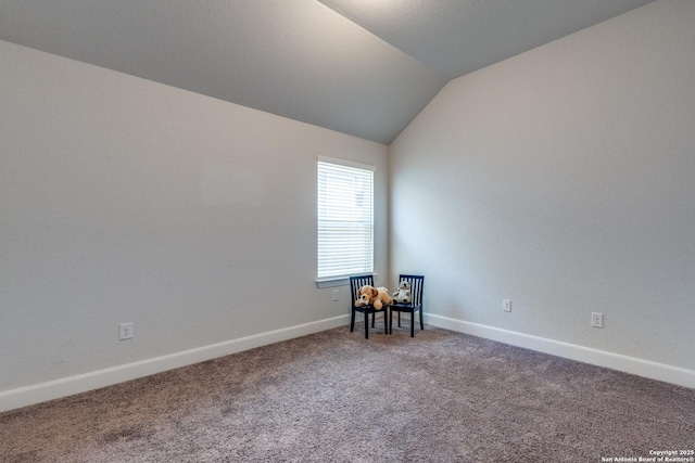 carpeted empty room featuring lofted ceiling